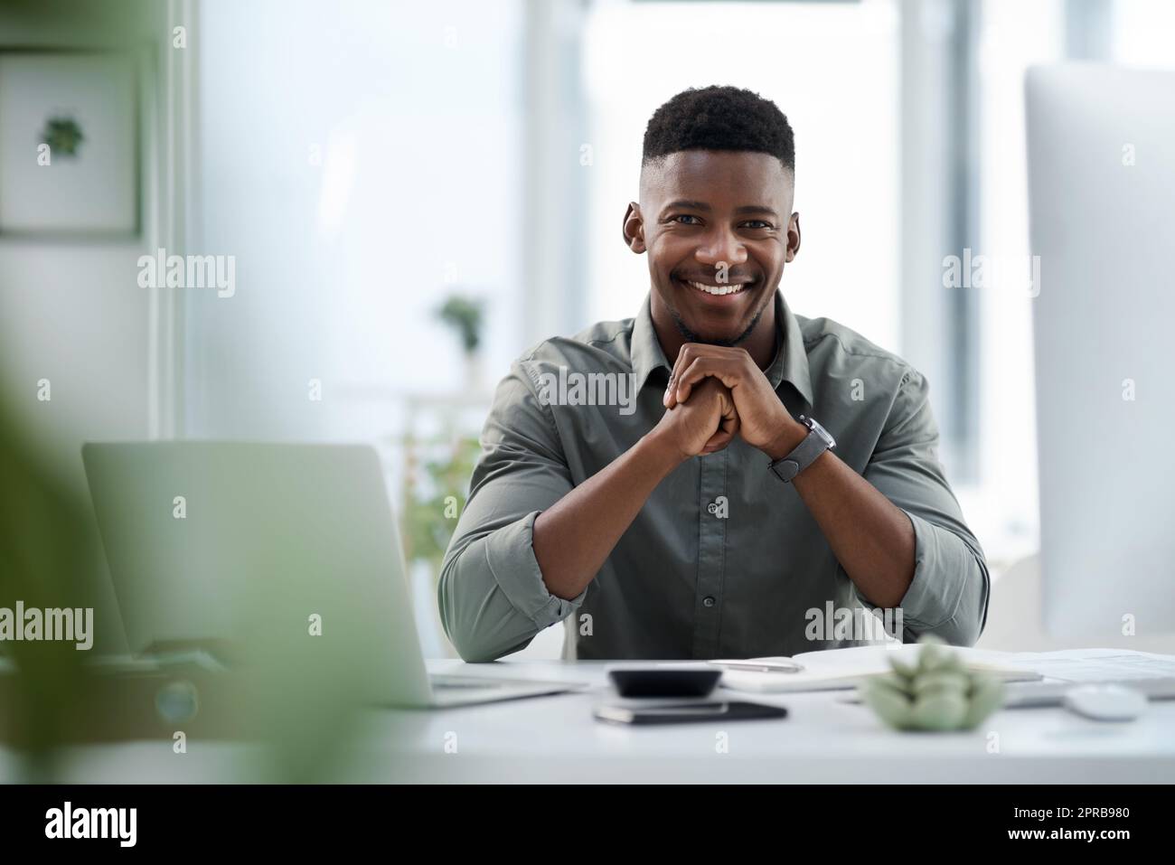 Svegliarsi ogni giorno è fondamentale: Un giovane uomo d'affari che lavora su un computer in ufficio. Foto Stock