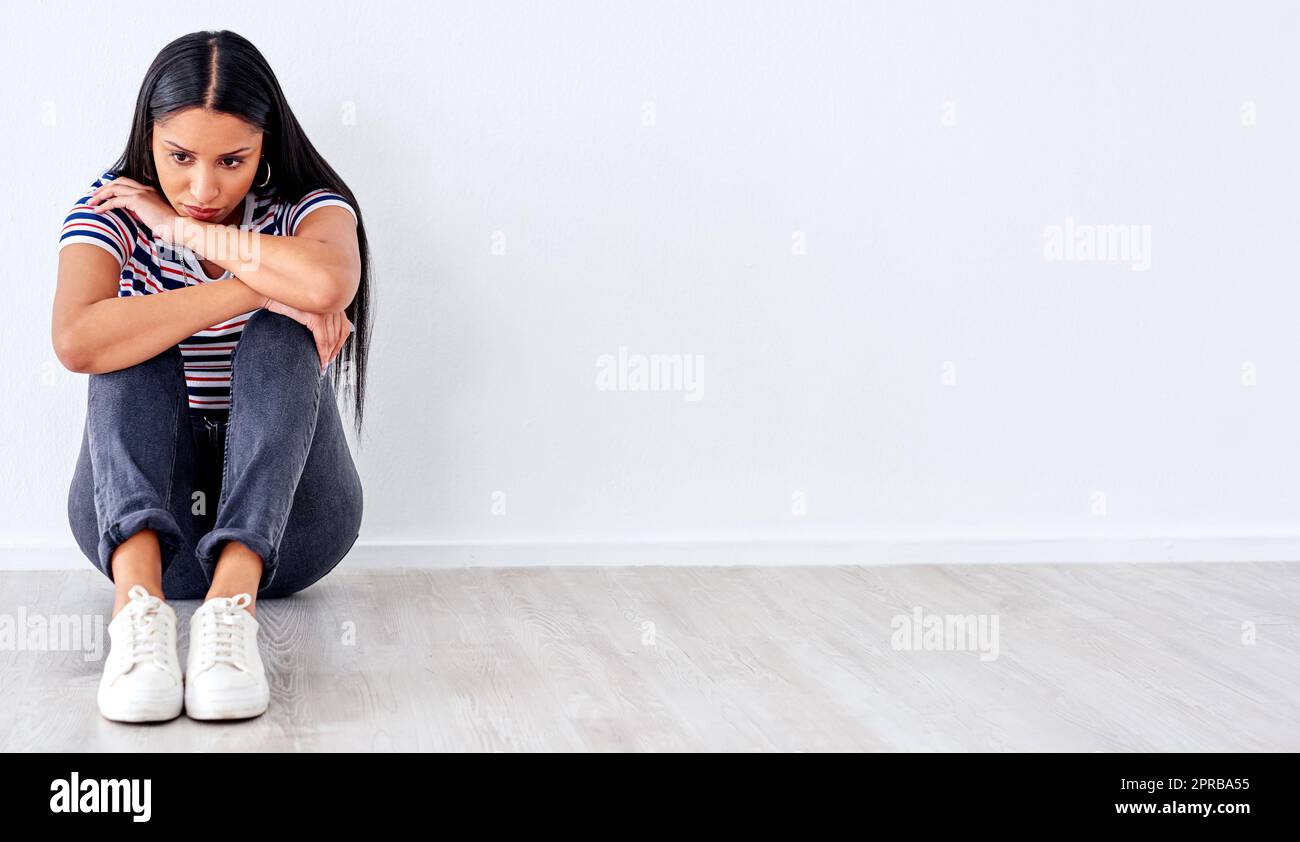 Im esausto di cercare di essere più forte di quanto mi sento. Studio girato di una giovane donna che guarda infelice su uno sfondo bianco. Foto Stock