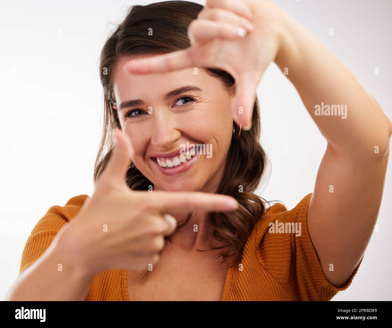 La fotocamera ti ama. Studio girato di una giovane donna che fa una cornice con le mani su uno sfondo bianco. Foto Stock