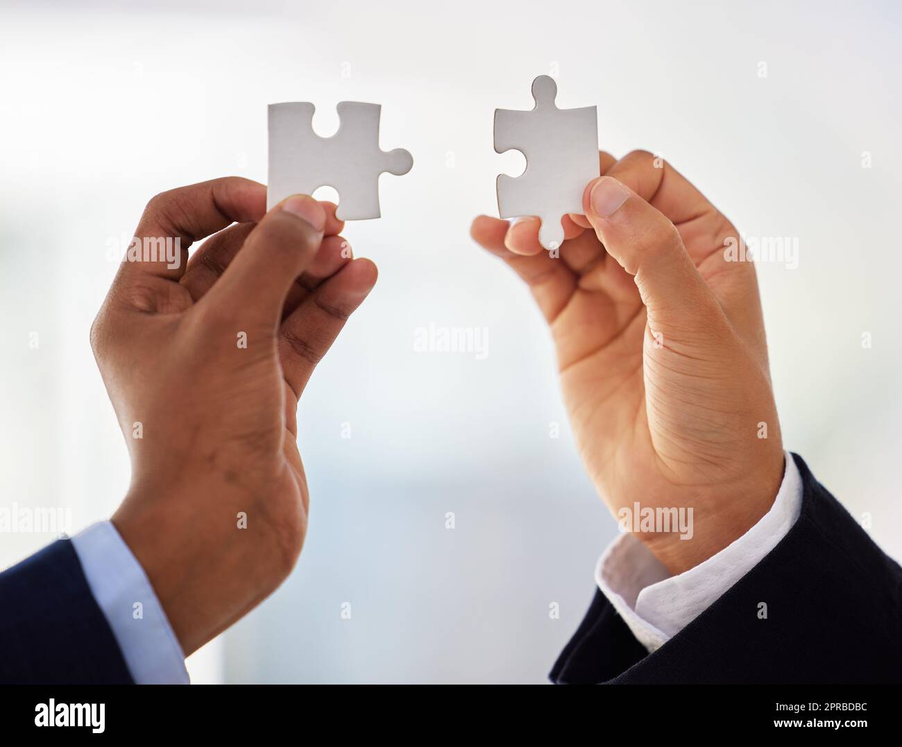 Il suo tutti insieme ora. Due inriconoscibili uomini d'affari che completano un puzzle. Foto Stock