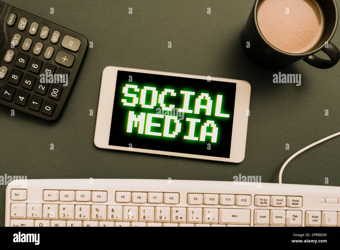 Scrittura visualizzazione testo social media. Canale di comunicazione Word for Online microblogging rete cellulare con nuovo messaggio sulla scrivania con tastiera, calcolatrice e caffè. Foto Stock