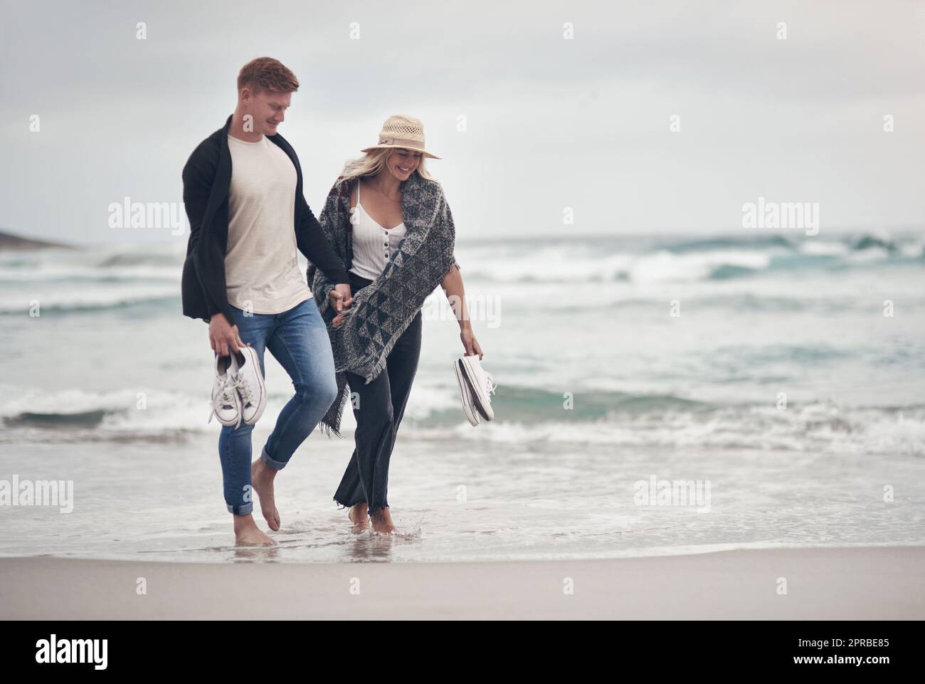 Ci piace andare in posti che ci avvicinano, una coppia che tiene le mani mentre passeggi sulla spiaggia. Foto Stock