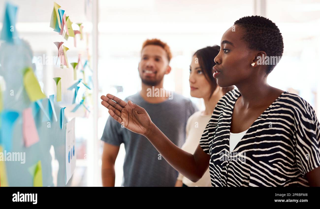 La creatività consiste nel creare opportunità per problemi: Una giovane donna d'affari che si fa il brainstorming con i suoi colleghi in un ufficio. Foto Stock