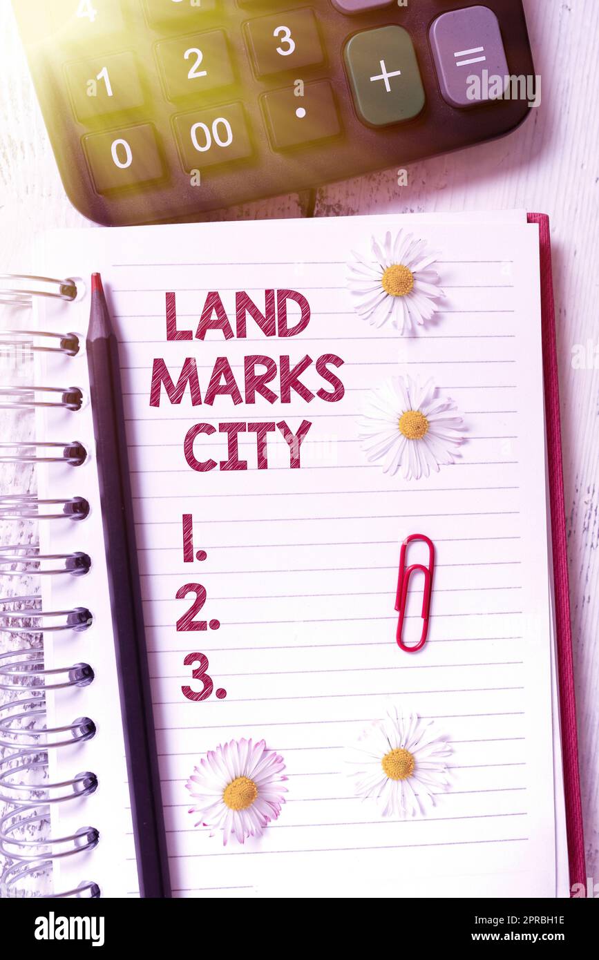 Testo che mostra l'ispirazione Land Marks City. Panoramica aziendale importanti luoghi di architettura nelle città da visitare nuove idee scritte su notebook con fiori, matita e clip. Foto Stock