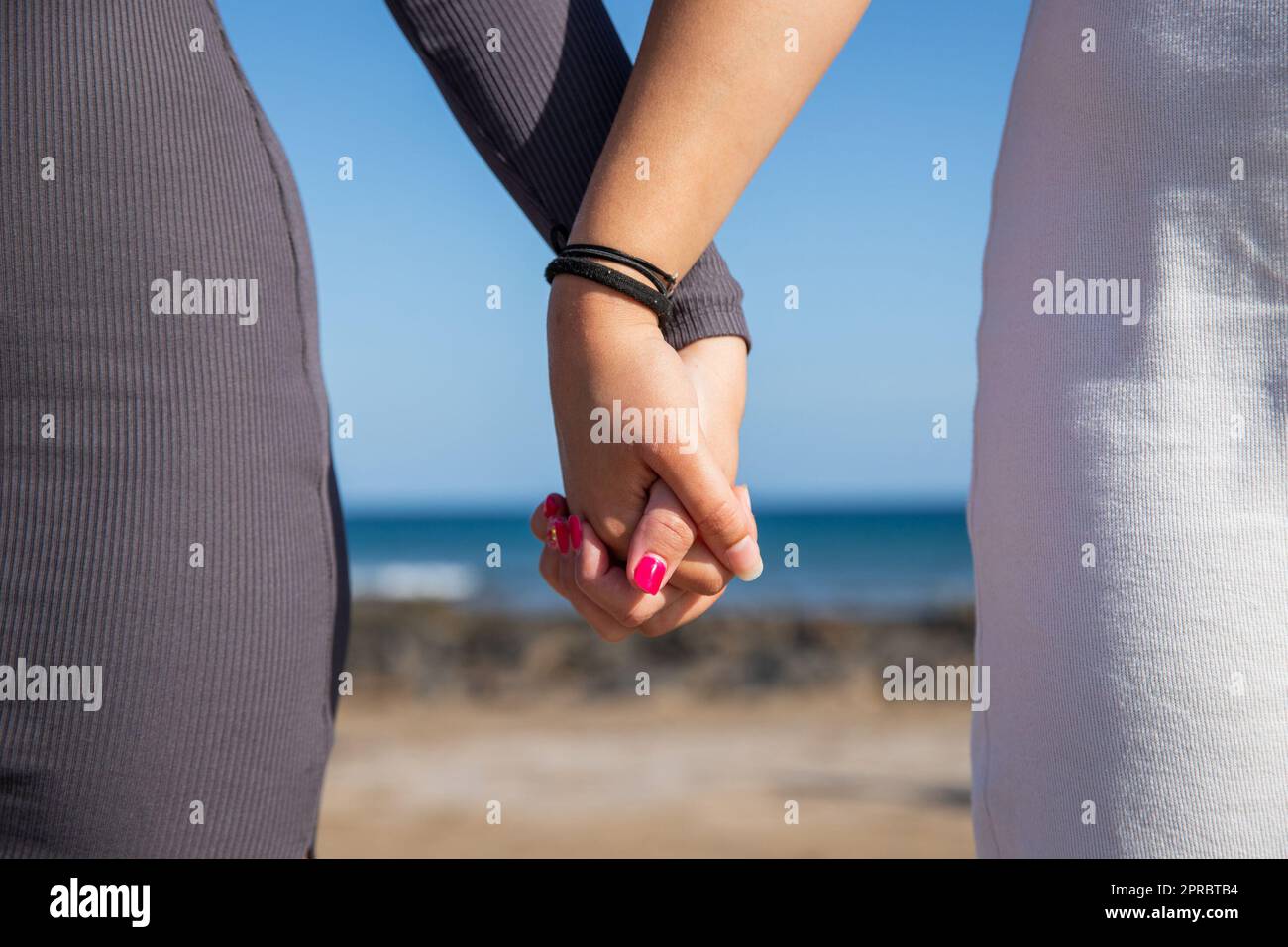 Primo piano di due mani femminili unite, concetto di sostegno tra le donne. Foto Stock