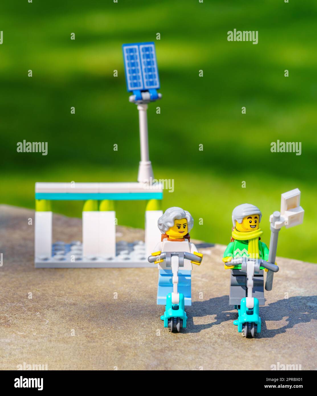 Coppia più anziana che cavalca gli scooter elettrici che prendono un selfie. Invecchiamento concetto migliore gli anziani attivi abbracciano la tecnologia, compreso il trasporto ecologico Foto Stock