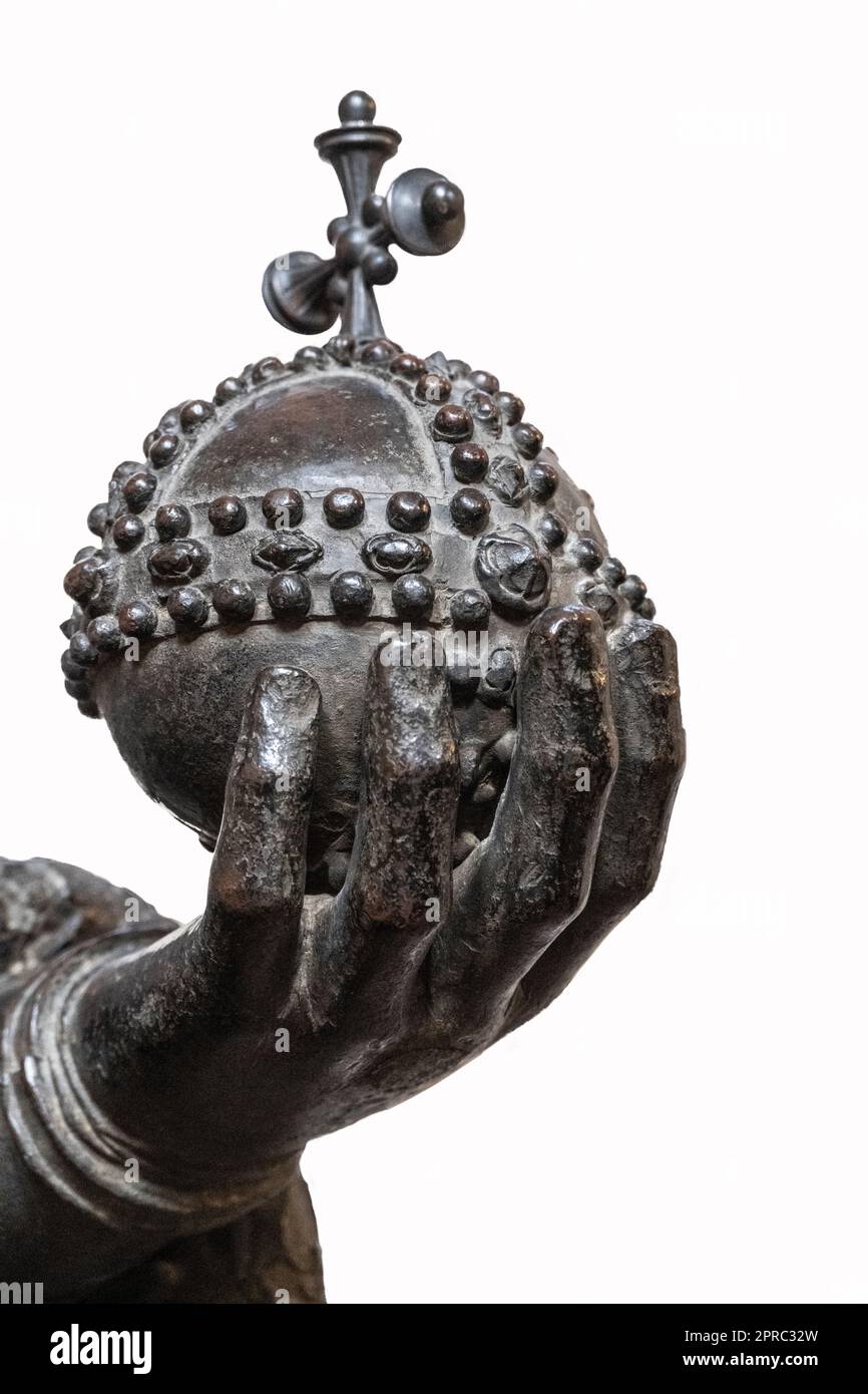 ritaglio con fondo bianco di una mano di bronzo che tiene la corona reale con una croce sulla sommità Foto Stock