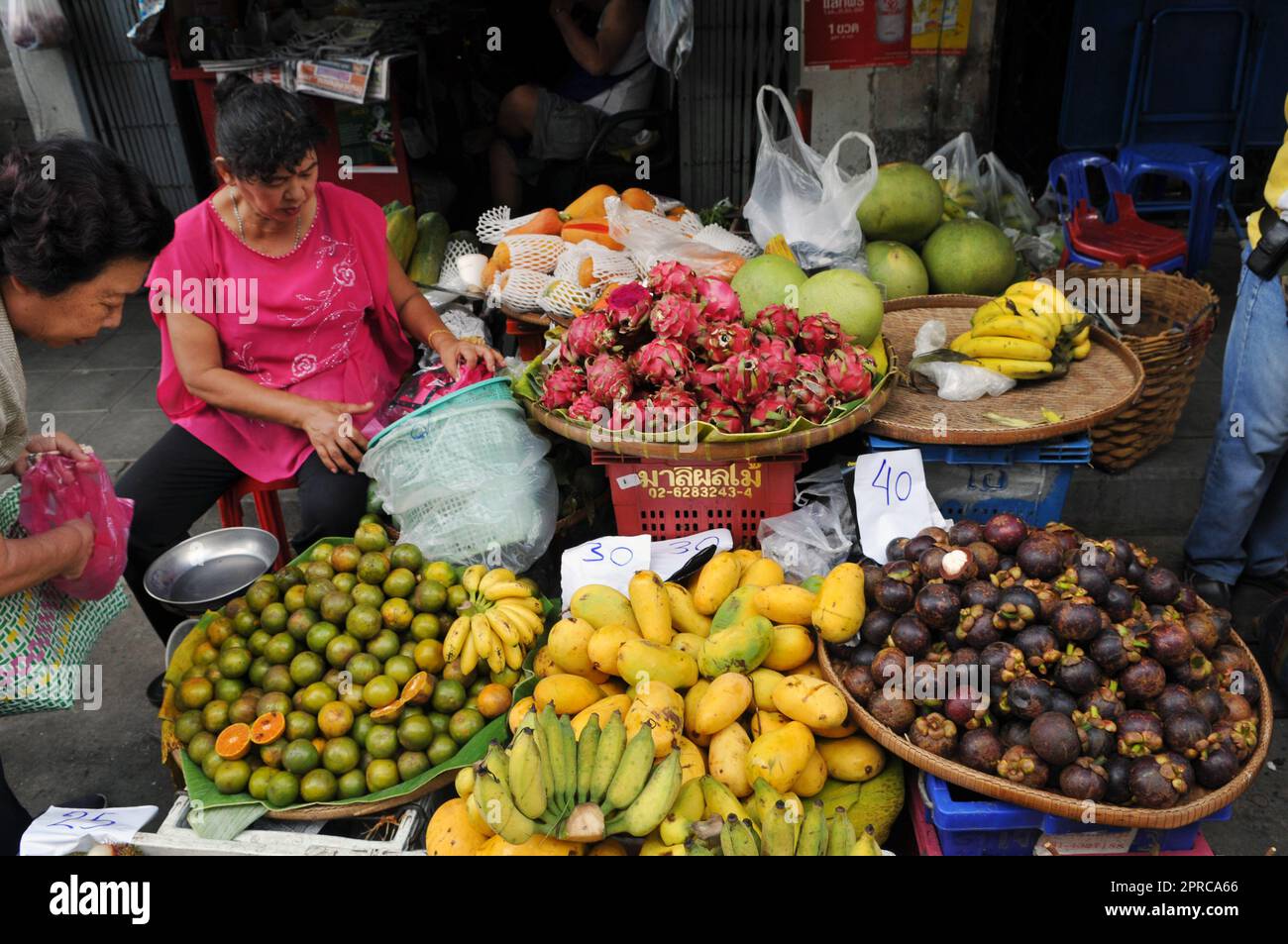 Un venditore di frutta al mercato Soi Prachum vicino Silom Road a Bangkok, Thailandia. Foto Stock