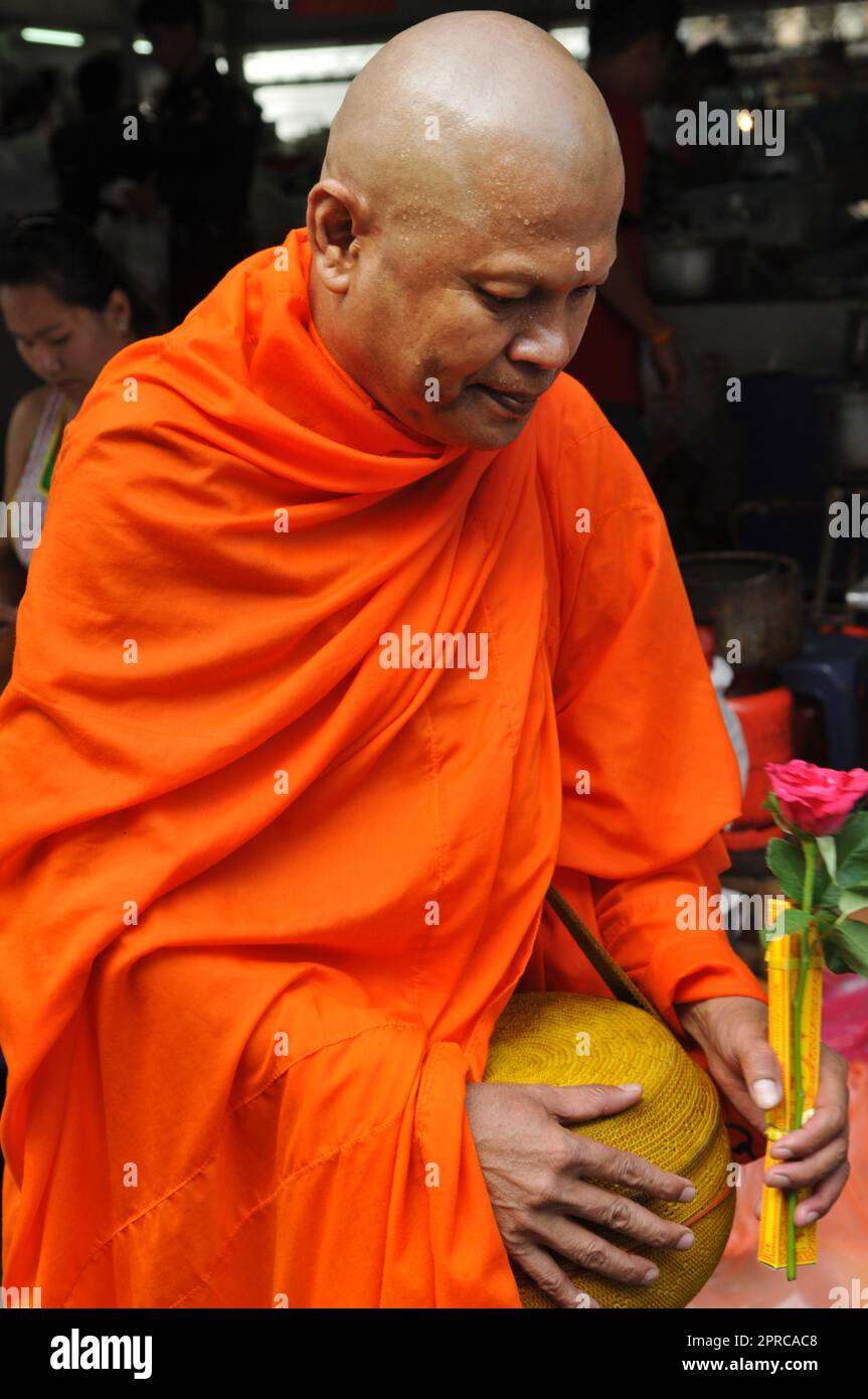 Un monaco buddista tailandese benedice la gente del posto e riceve le elemosine come parte di un rituale mattutino. Foto scattata a Bangkok, Thailandia. Foto Stock