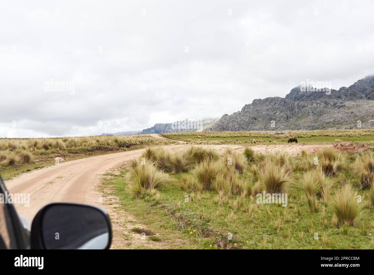 Vista da un'auto che viaggia su una strada rurale nella regione di Los Gigantes, un massiccio di montagna che appartiene alla zona settentrionale di Sierras Grandes, un de turistico Foto Stock