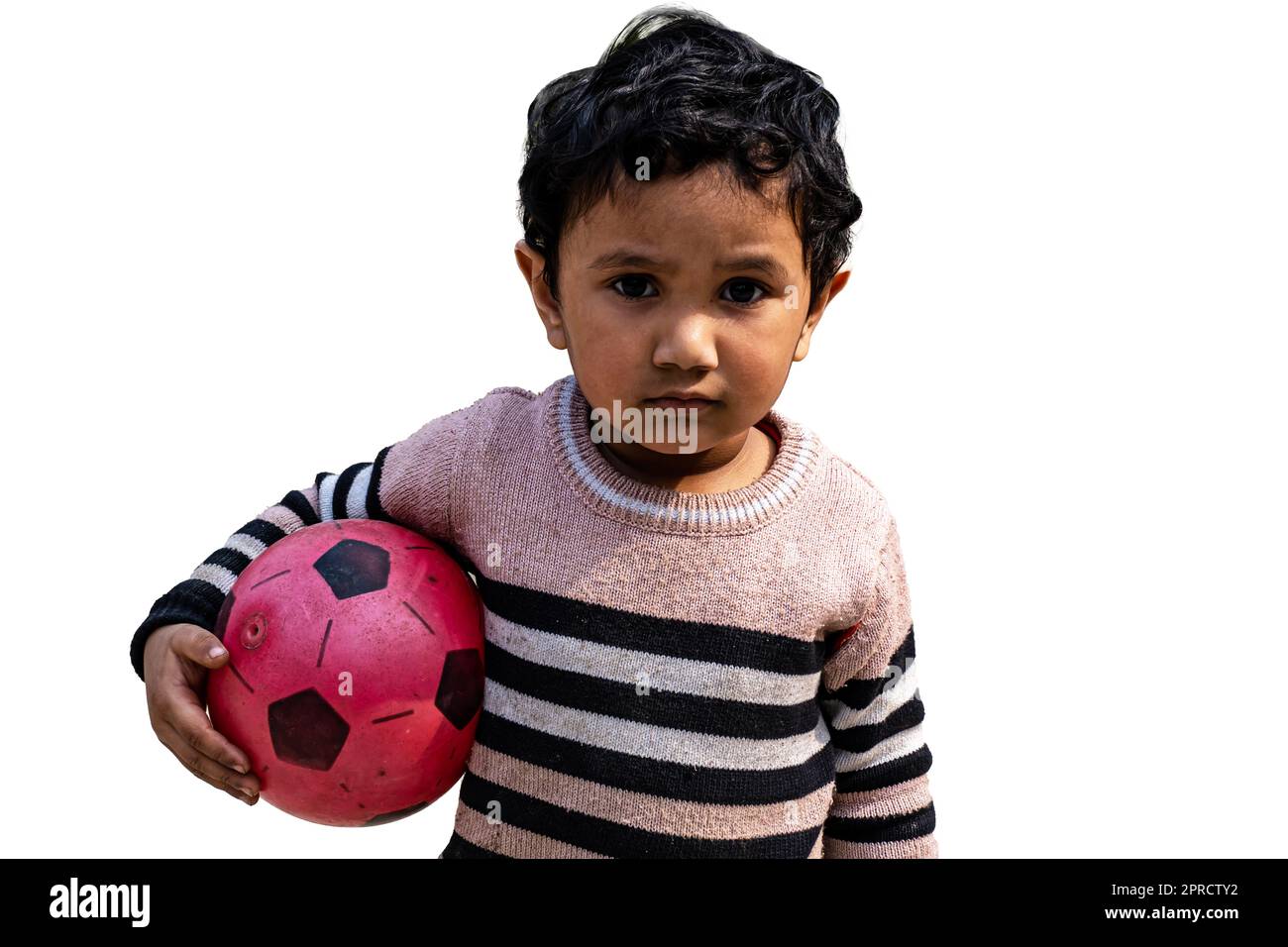 Little Boy in piedi sul cortile con un calcio di calcio. I giovani attivi potranno trascorrere una giornata invernale all'aperto. Foto Stock