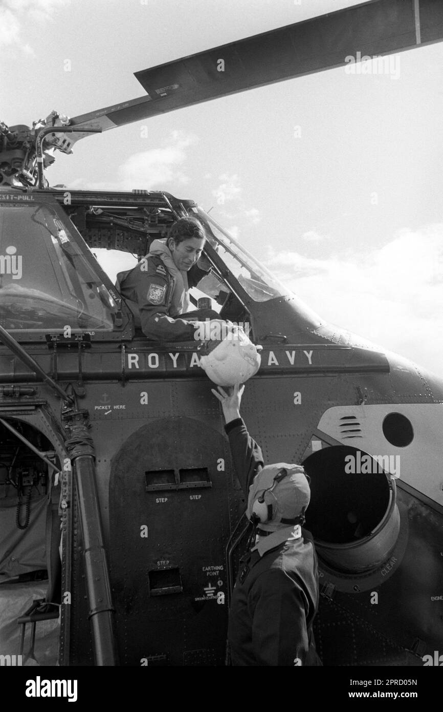 Foto del file datata 09/09/74 del tenente Navale il Principe di Galles è stato consegnato il suo casco volante da un equipaggio di terra prima di salire per il suo primo volo "dual control" con l'istruttore Lueutenant Commander Alan MacGregor in un elicottero Royal Navy Wessex V. Le foto di ogni anno della vita del Re sono state compilate dall'agenzia di stampa PA, per celebrare l'incoronazione di Carlo III. Data di emissione: Giovedì 27 aprile 2023. Foto Stock