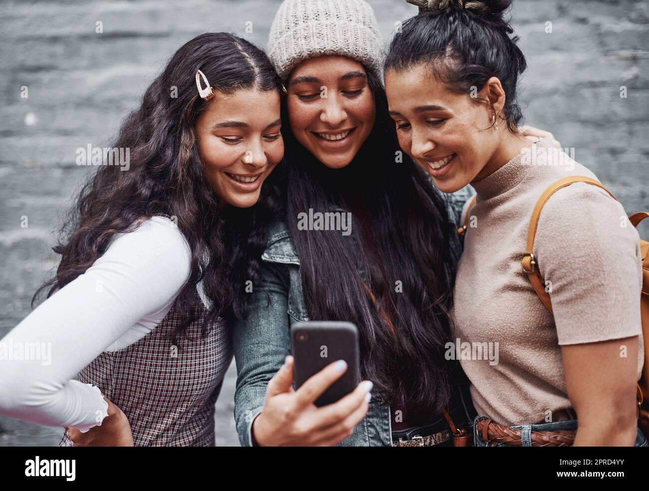 Tempo selfie. Ritratto corto di un gruppo attraente di sorelle in piedi insieme e prendere un selfie con un cellulare in città. Foto Stock