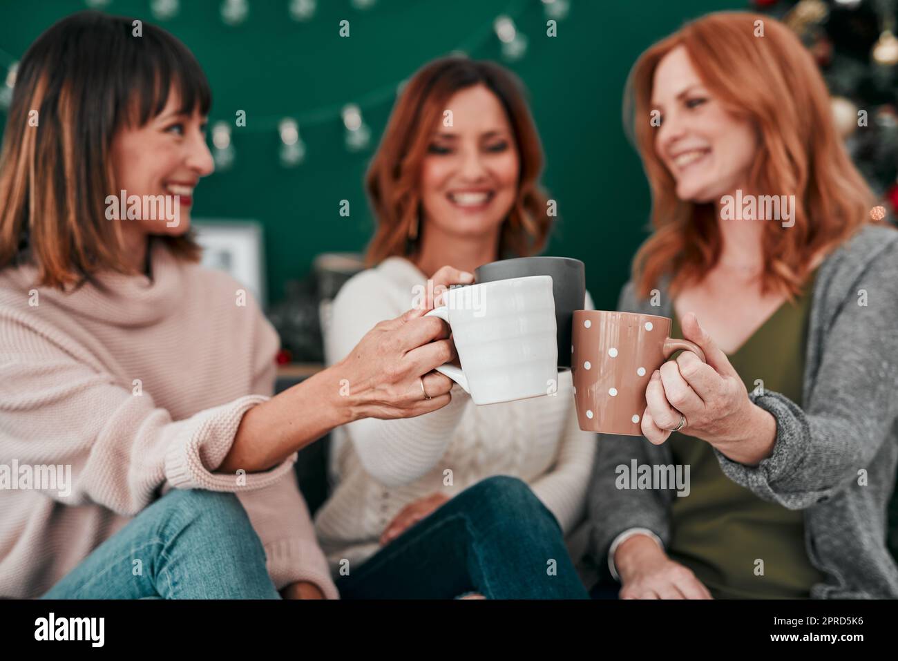 Chi pensava di sposarsi brindisi con caffè. Tre donne attraenti che hanno un caffè sul divano insieme a casa. Foto Stock