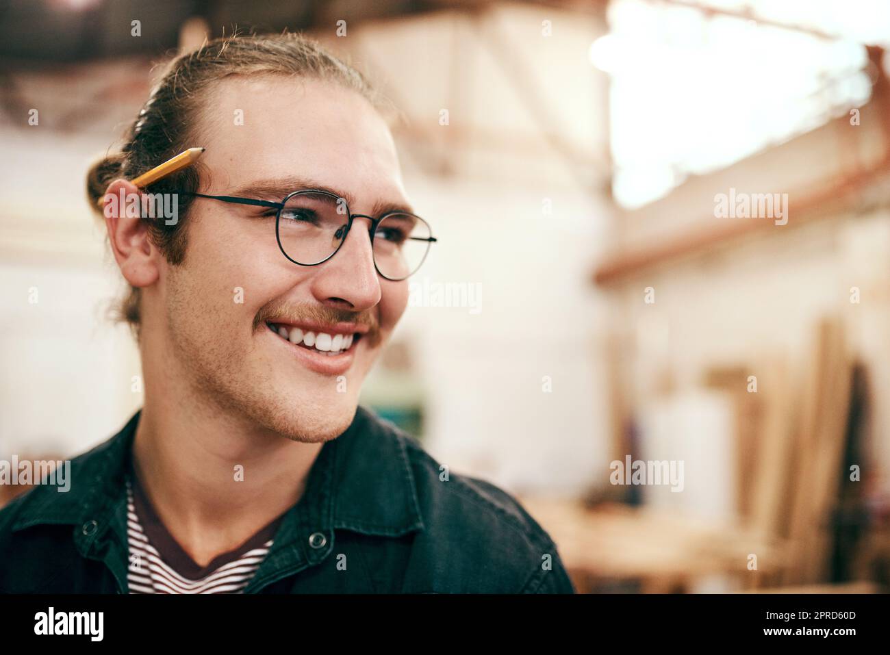 Questo laboratorio è il mio luogo felice: Un bel carpentiere che lavora all'interno del suo laboratorio. Foto Stock