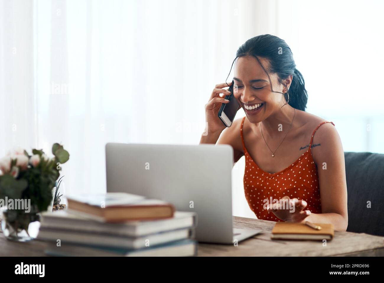 È sempre un piacere aiutare i clienti felici. Una giovane donna d'affari attraente seduto nel suo ufficio e utilizzando il suo laptop durante una telefonata. Foto Stock