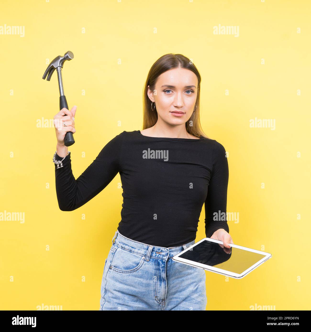 Centro servizi. Riparazione del notebook. Il cacciavite femmina svita i bulloni del computer portatile su sfondo giallo Foto Stock