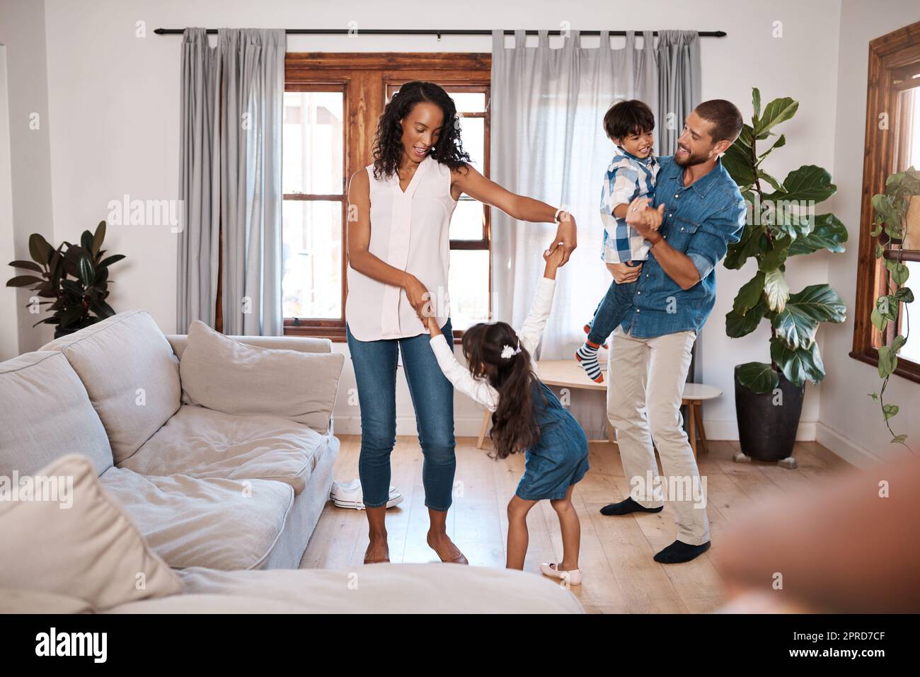 Fare la loro danza felice. Una famiglia di quattro ballare insieme a casa. Foto Stock