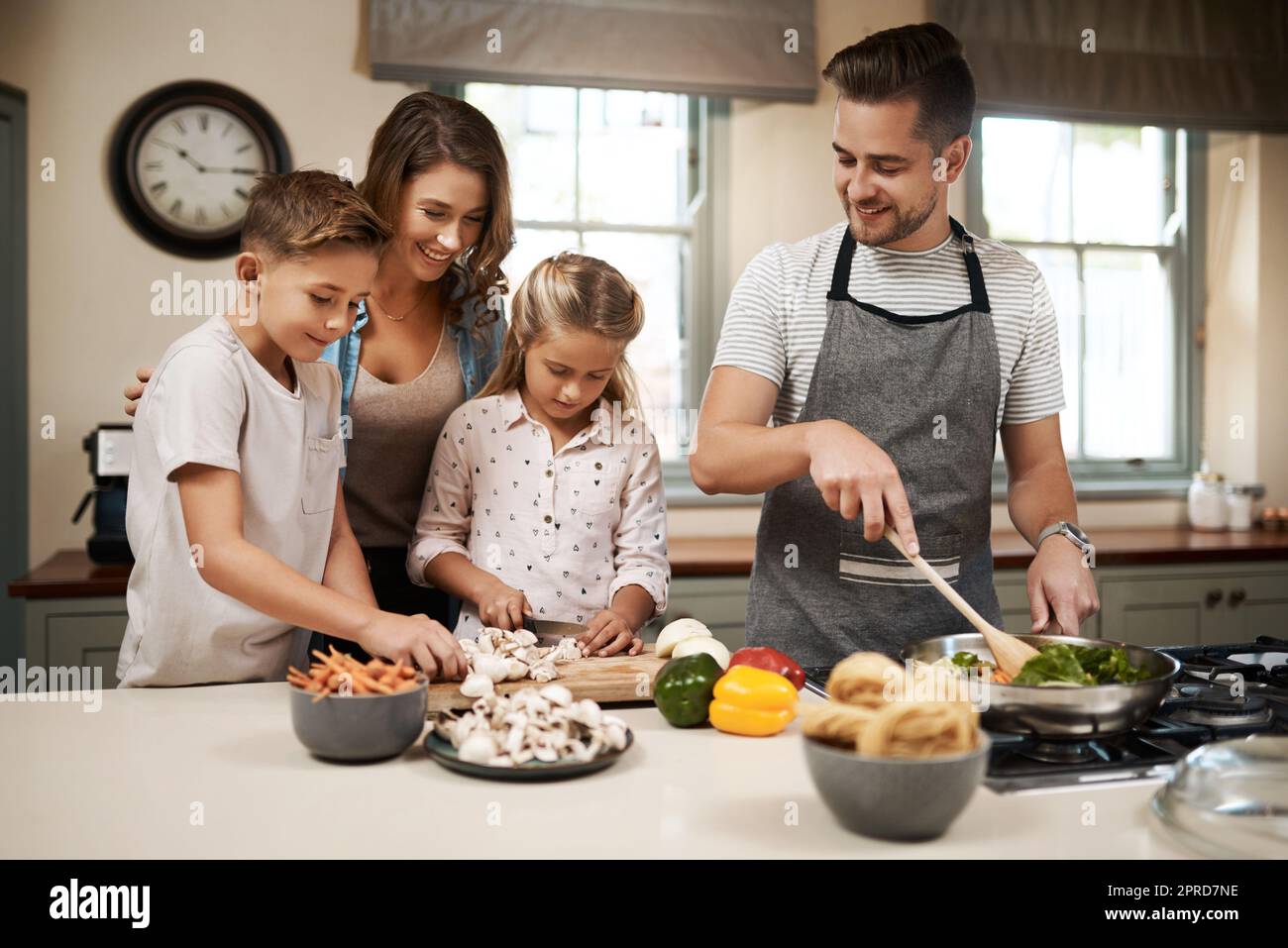 Mangiamo, cuociamo e gusteremo come una famiglia. Una giovane famiglia che cucinano in cucina. Foto Stock