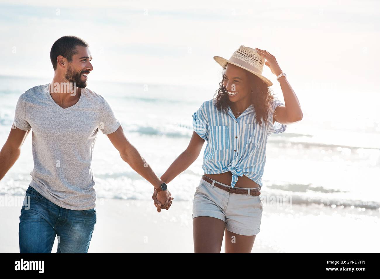 Una giovane coppia che cammina lungo la spiaggia. Foto Stock