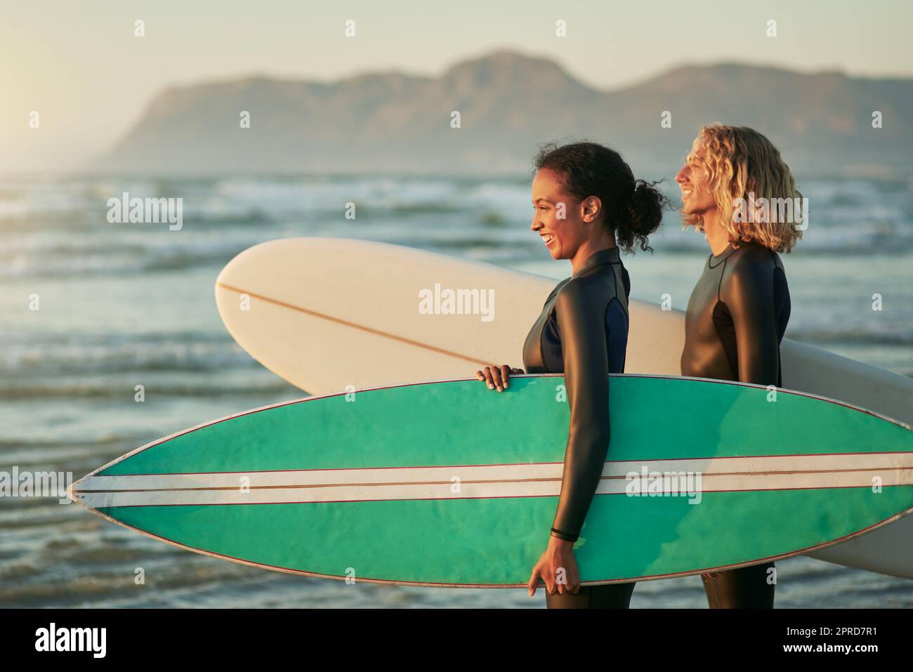 Vivevano una vita piena di avventura, una giovane coppia allegra che andava a fare surf in spiaggia. Foto Stock