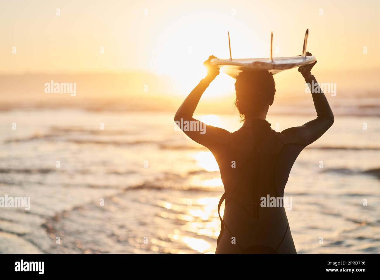 Im destra dove Ive apparteneva sempre. Ripresa di una surfista che porta la sua tavola da surf sulla testa in spiaggia. Foto Stock