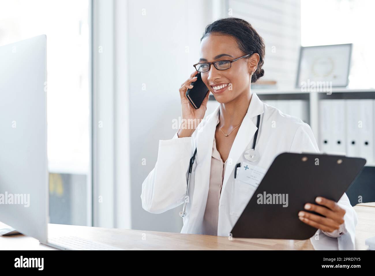 Ho i risultati dei test con me. Un medico che effettua una telefonata utilizzando il suo smartphone. Foto Stock