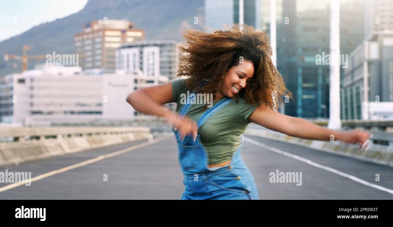 Balla di più, stress di meno. Una giovane donna attraente che esegue una routine di danza di strada durante il giorno all'aperto. Foto Stock