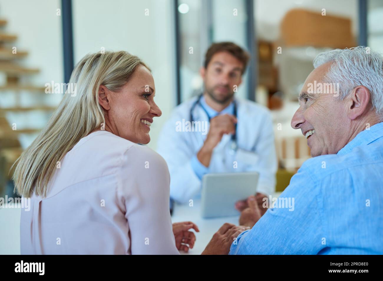 Queste sono notizie meravigliose. Un anziano allegro e sua figlia che hanno una discussione all'ufficio dei medici. Foto Stock
