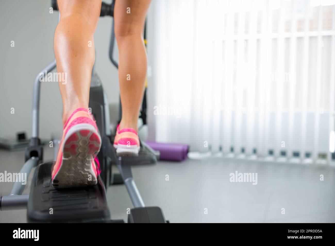 Giovane donna gambe muscolare sullo stepper/tapis roulant, primo piano Foto Stock