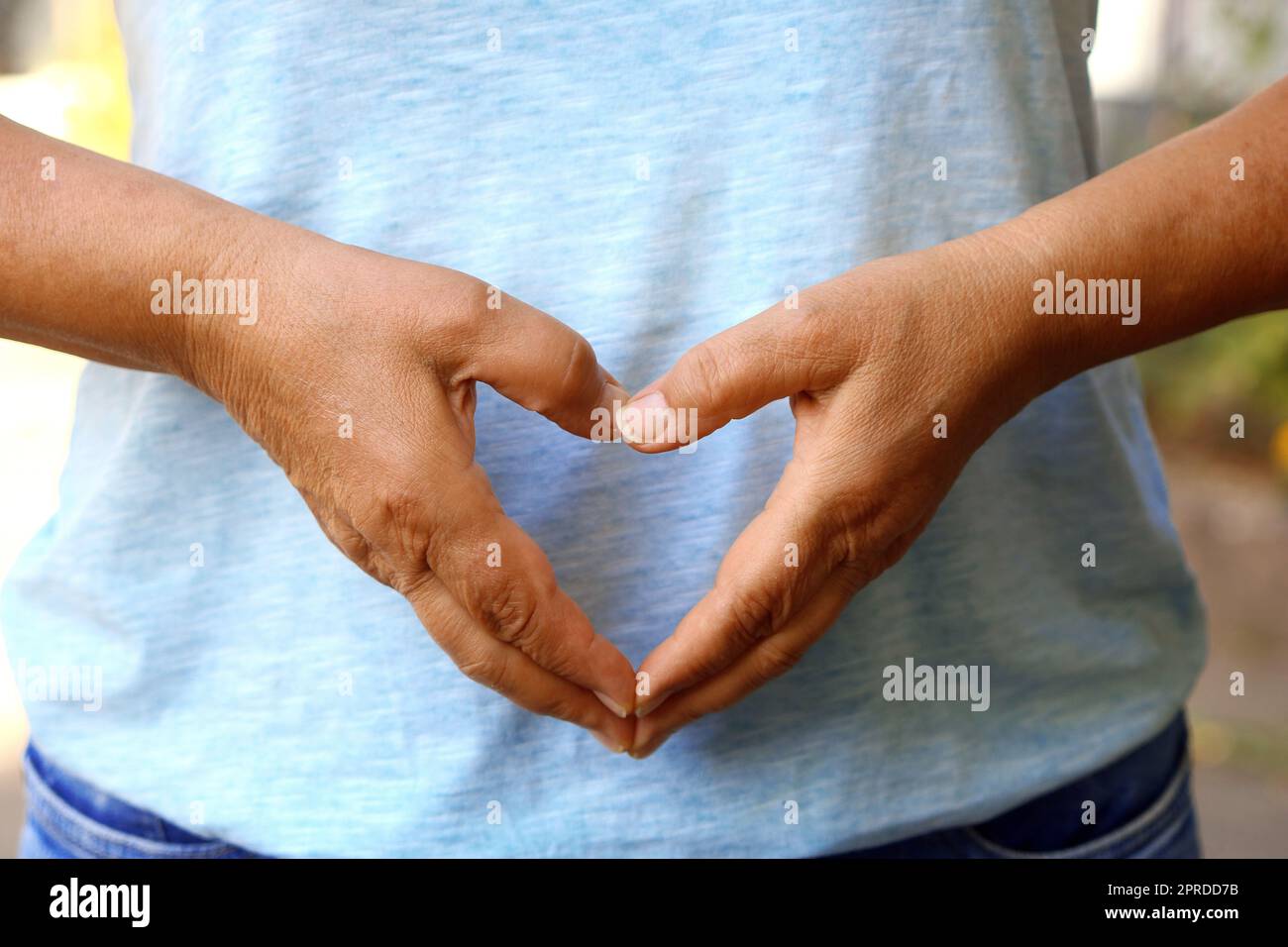 La donna forma un cuore con le mani Foto Stock