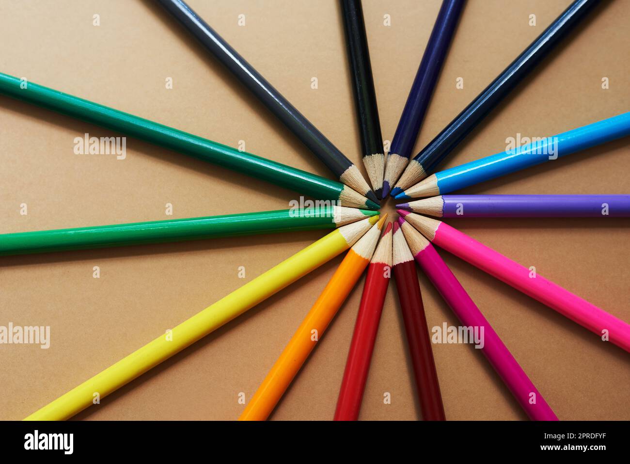 Vivete la vostra vita a colori. Studio girato di matite di colori diversi su uno sfondo marrone. Foto Stock