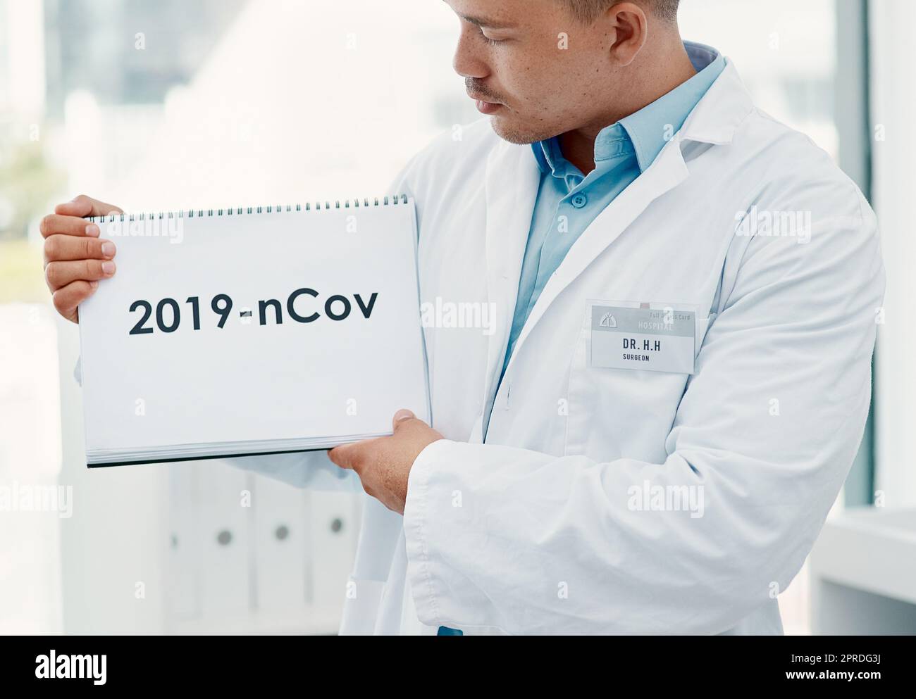 L'anno in cui la nostra vita è cambiata per sempre. Un giovane scienziato che ha un segno con 2019-nCov su di esso in un laboratorio moderno. Foto Stock