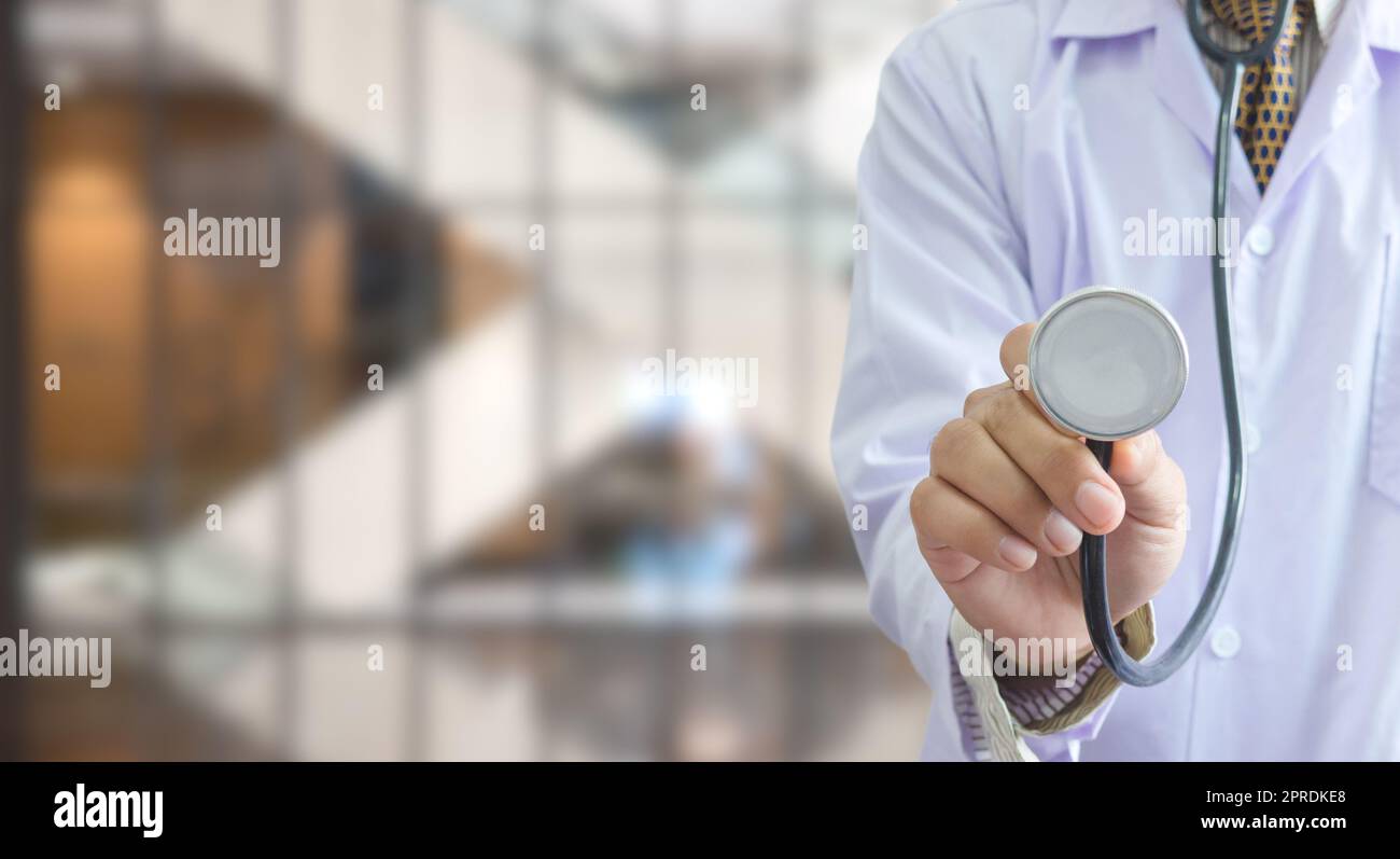 Uniforme medico che tiene uno stetoscopio in background di ospedale copia Space.Business concetto di assistenza sanitaria. Foto Stock