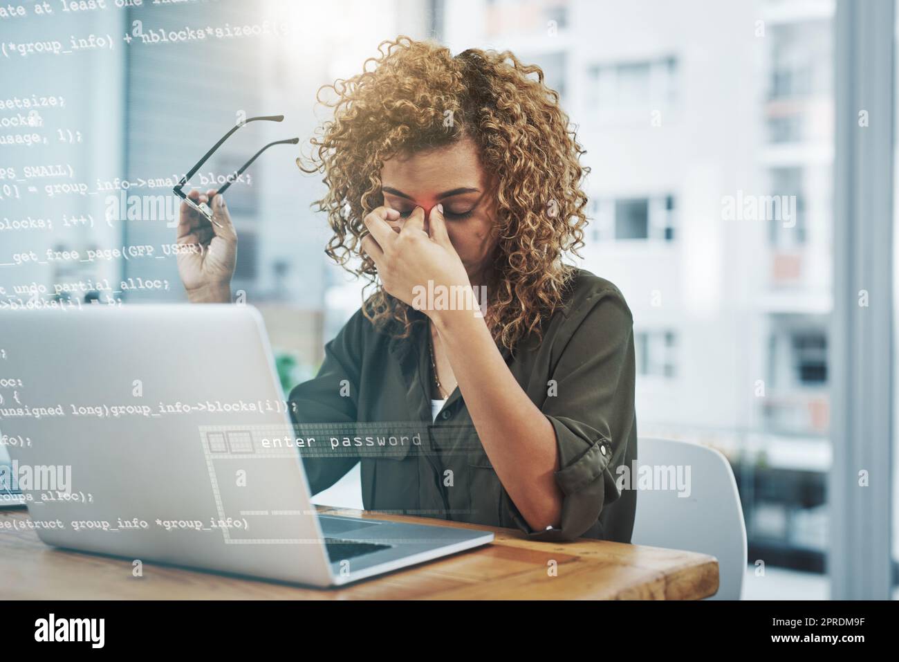 Questo mal di testa non Vai via. una giovane donna d'affari che soffre di mal di testa mentre usa il suo notebook al lavoro. Foto Stock