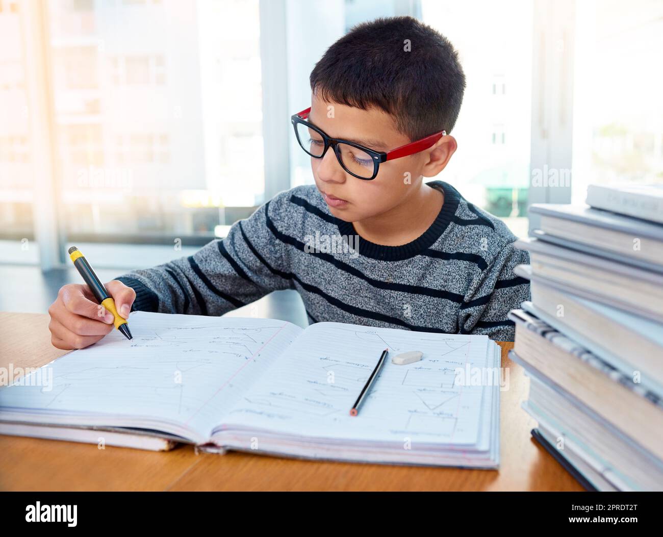 Mette sempre al primo posto il suo lavoro scolastico, un ragazzo determinato che fa i compiti a casa. Foto Stock