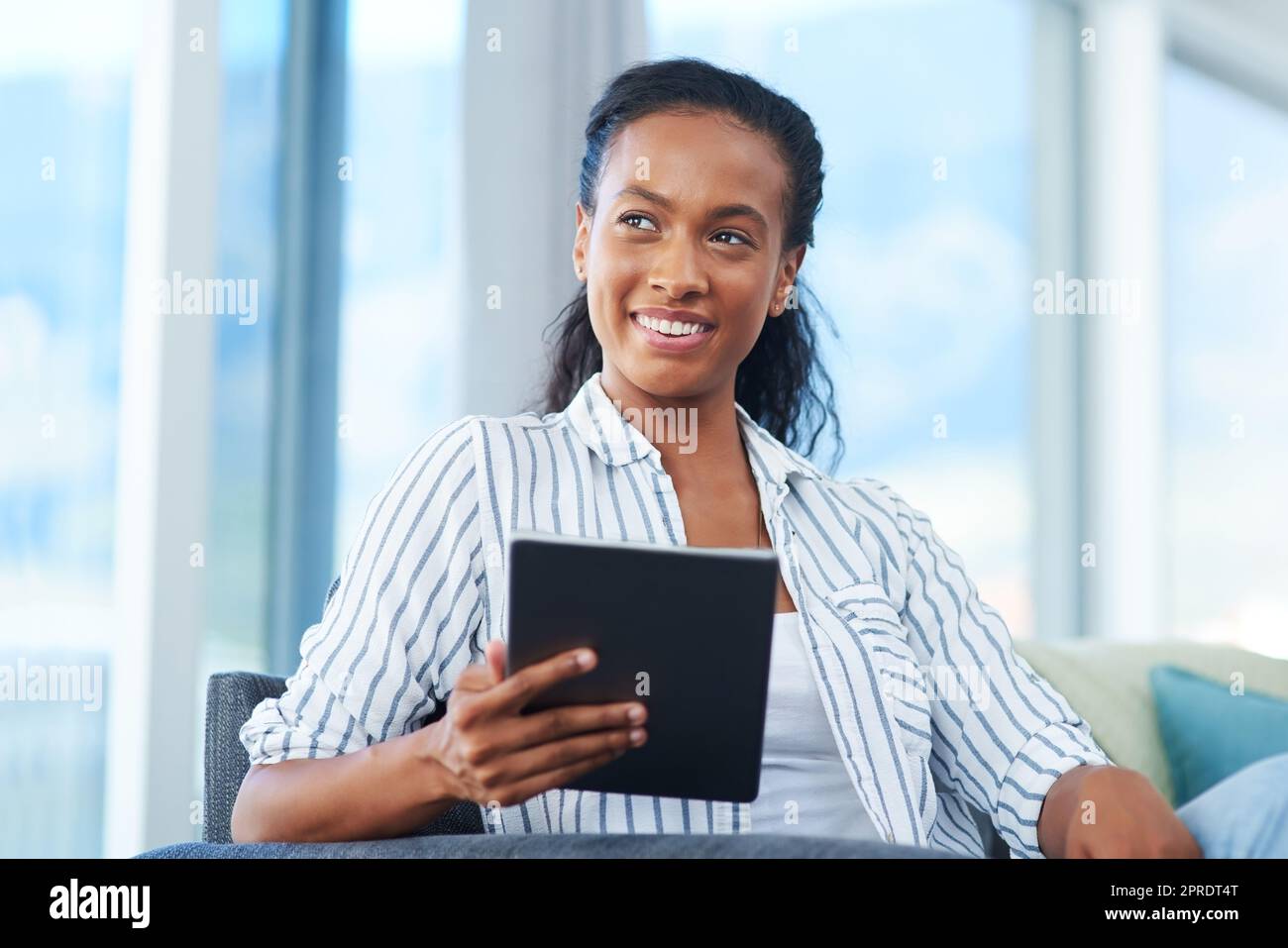 Trascorrere il tempo libero a casa, una giovane donna che usa un tablet digitale a casa. Foto Stock