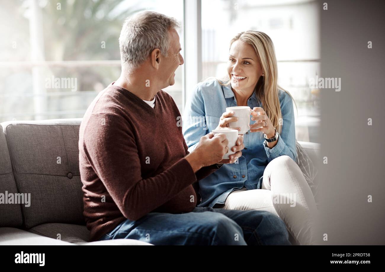 Date night fatto dal comfort di casa. Una coppia matura godendo una rilassante pausa caffè sul divano insieme a casa. Foto Stock