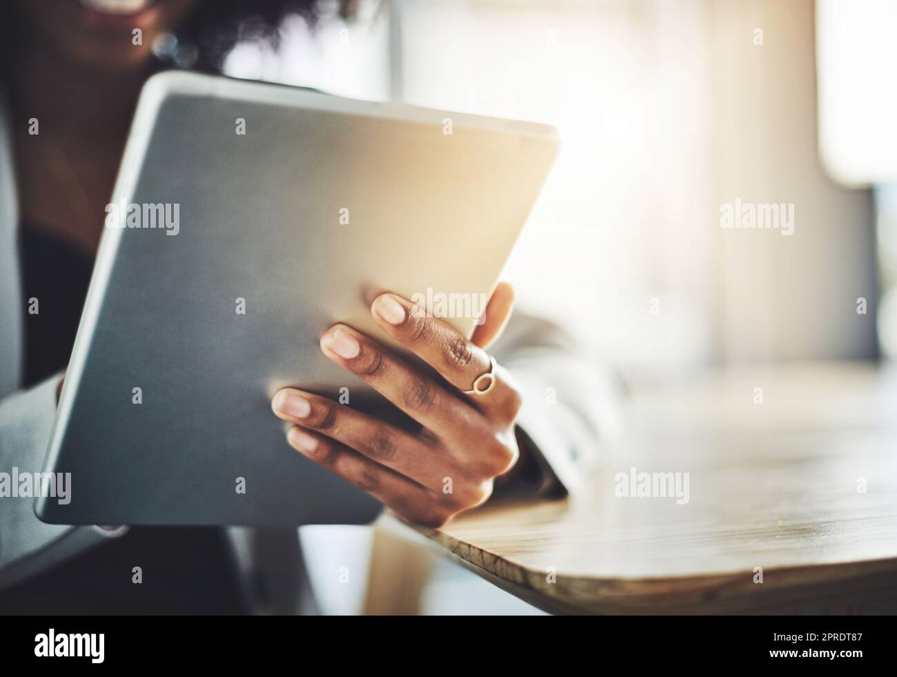 Il suo dispositivo più maneggevole rimane sempre vicino. Primo piano di una donna d'affari che utilizza un tablet digitale in ufficio. Foto Stock