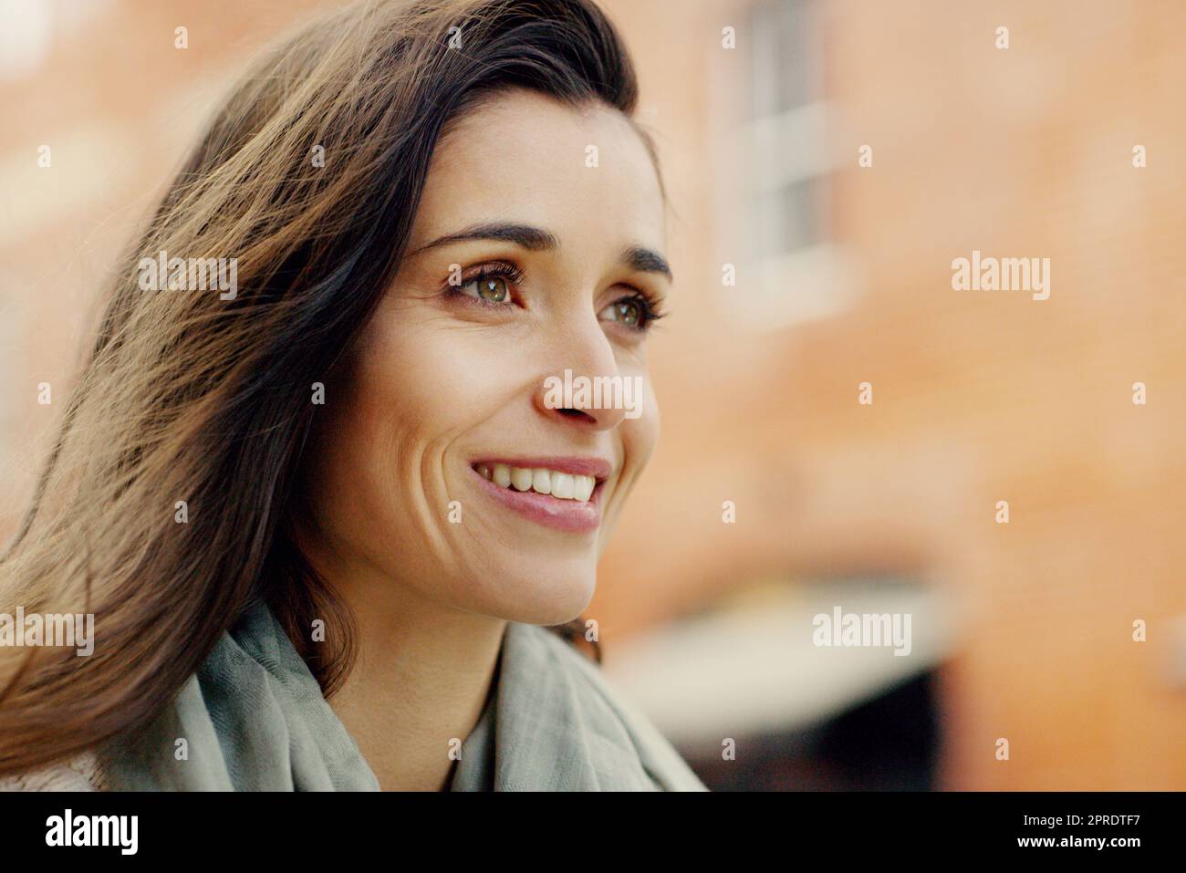 Osate affrontare ogni sfida che la città si pone. Primo piano di un'attraente giovane donna sorridente e in posa in città. Foto Stock