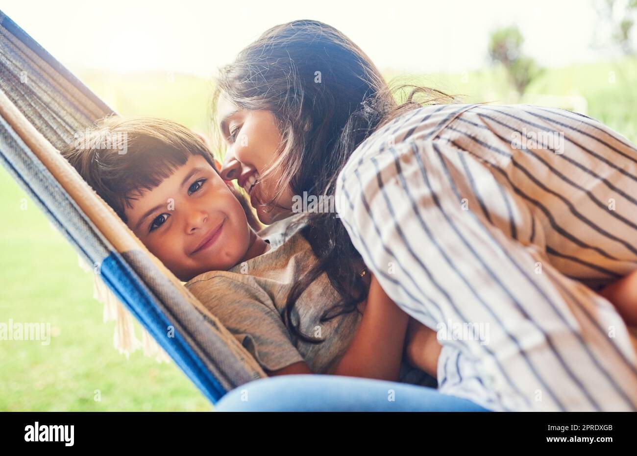 La mia mamma mi ama. Una giovane donna attraente e suo figlio si legano fuori sull'amaca. Foto Stock