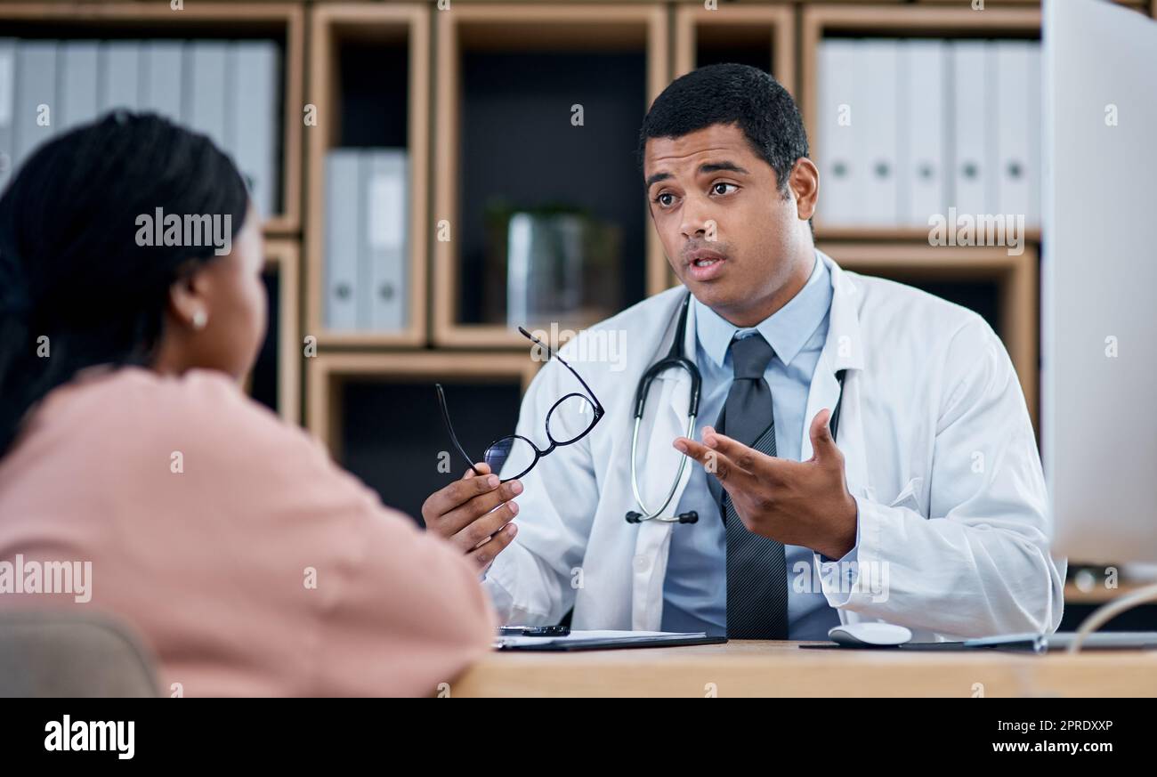 Medico che parla con il paziente in consultazione medica, controllo e visita in clinica, ospedale e centro sanitario. Professionista, medico di famiglia e lavoratore di prima linea che spiega i sintomi mentre fa domande donna Foto Stock