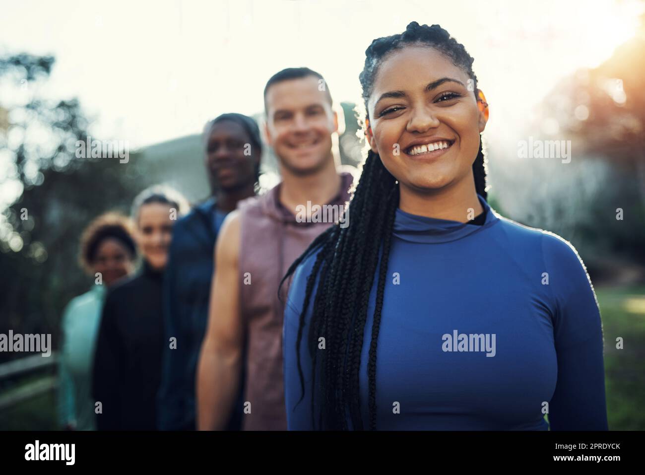 Cogliere l'opportunità per migliorare. Ritratto di un gruppo di giovani amici sportivi in fila mentre si allenano nella foresta. Foto Stock