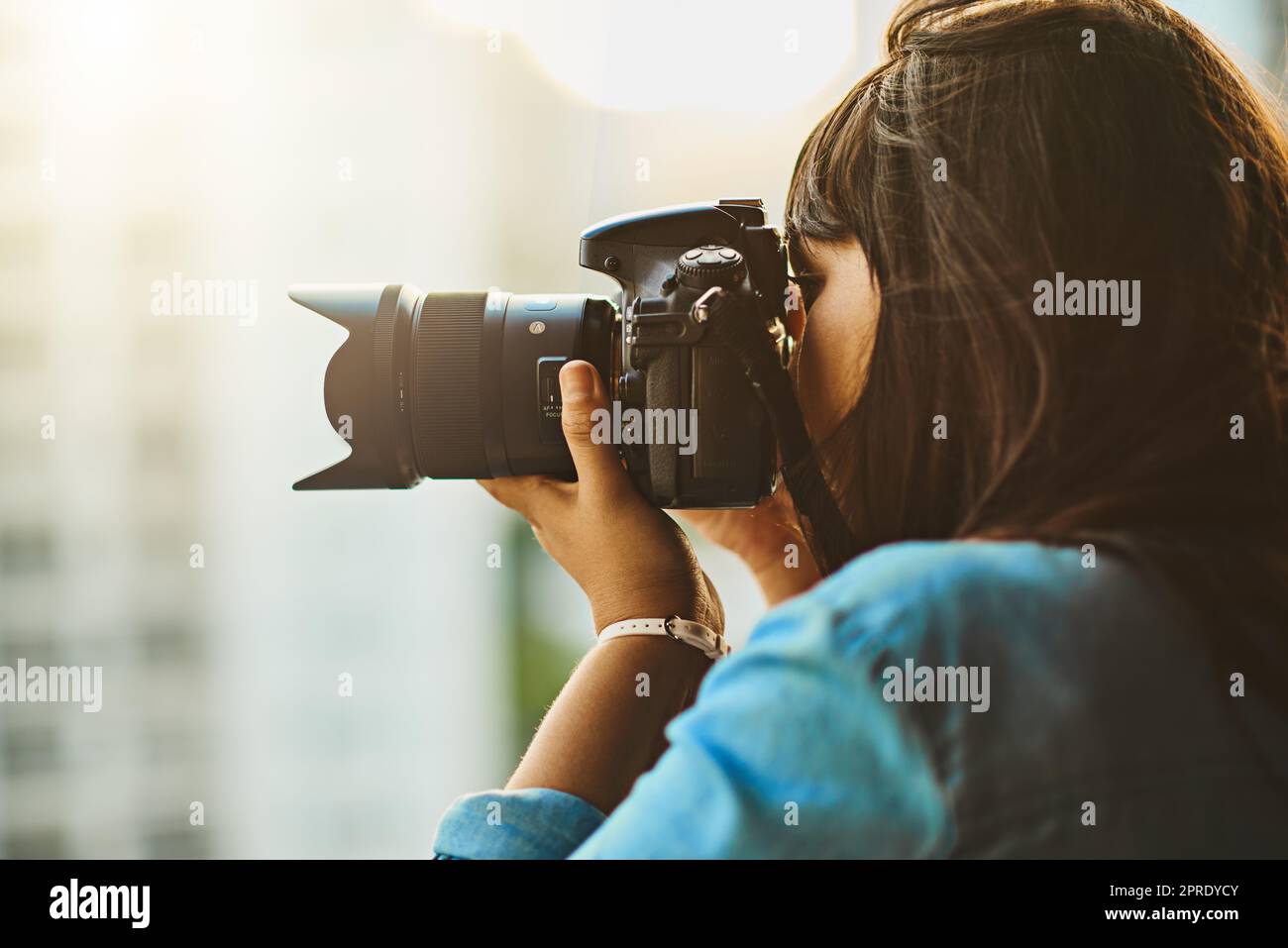 Vedere e catturare il mondo. Una donna che scatta foto con la sua fotocamera all'esterno. Foto Stock