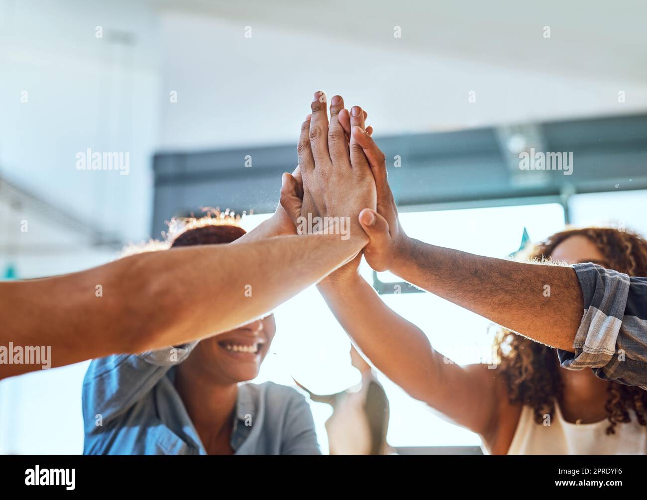 Il successo sarà sempre nostro alla fine della giornata: Un gruppo di uomini d'affari che si accaniscono insieme in un ufficio. Foto Stock