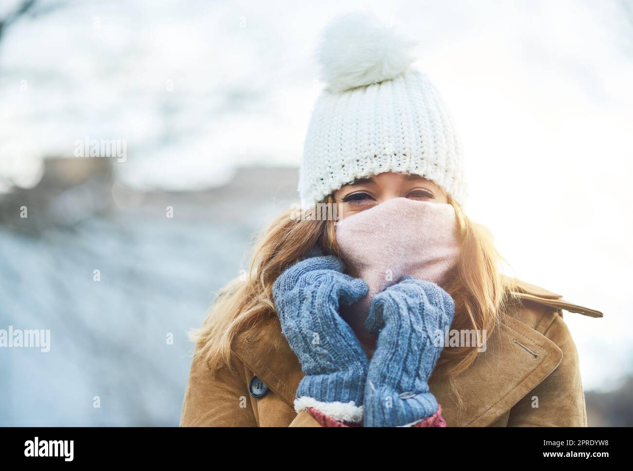 Im sentirsi coperto e caldo, ora di godere la neve. Una giovane donna attraente godendo di essere fuori nella neve. Foto Stock