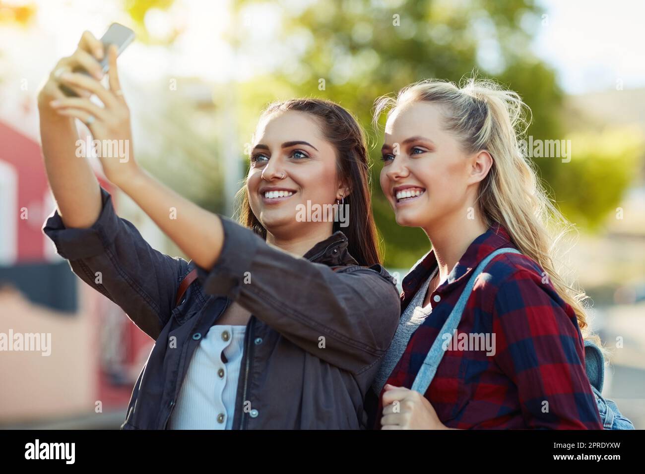 Scattiamo delle foto per dare un'occhiata alle nostre esperienze. Due belle amiche scattano un selfie in città. Foto Stock