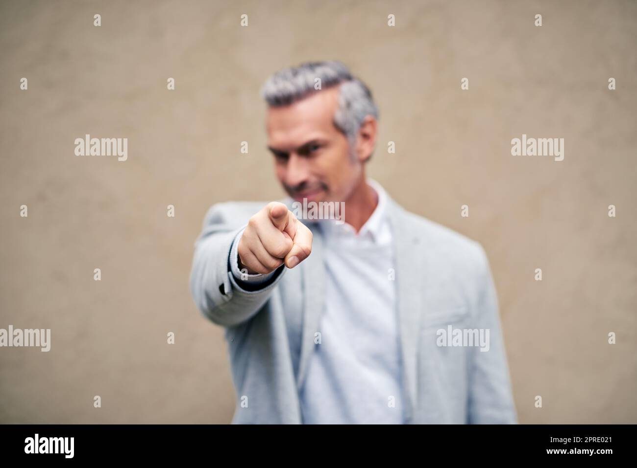 Siete quello scelto. Un uomo d'affari maturo elegantemente vestito che indica fuori. Foto Stock