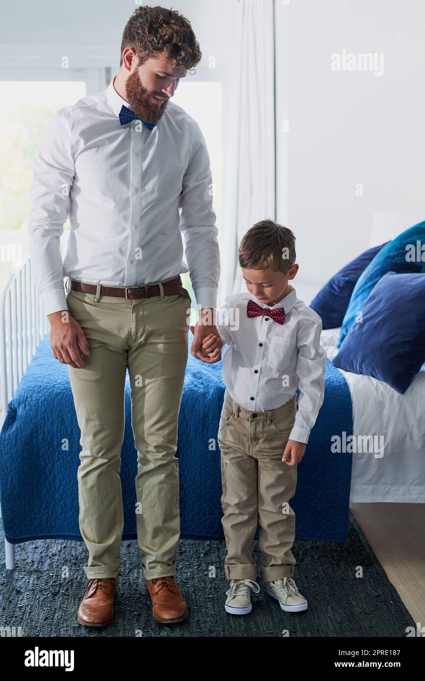 Come un padre come un figlio, un adorabile ragazzino e suo padre vestiti in abiti coordinati. Foto Stock