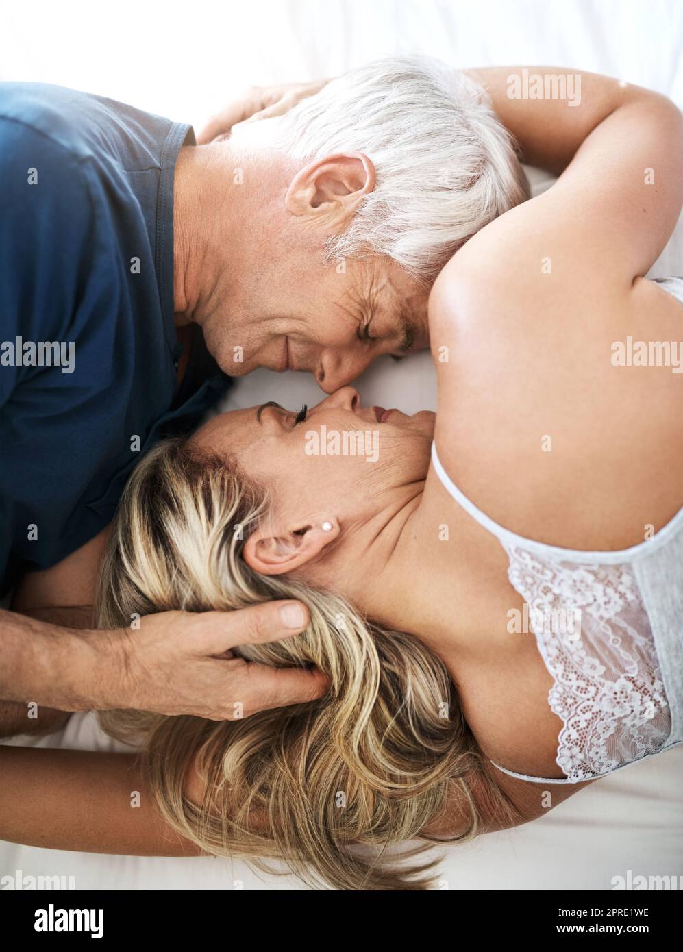Il vero amore porta la pace: Una coppia matura affettuosa che si trova a letto insieme a casa. Foto Stock